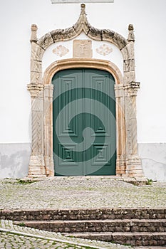 Green doorway of the ancient Igreja Matriz de Alte church in the small town of Alte, Portugal