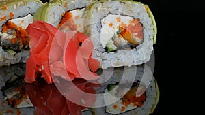 Green Dragon Sushi rolls and pink ginger. Sushi roll with salmon, vegetables and avocado closeup. Japan restaurant menu