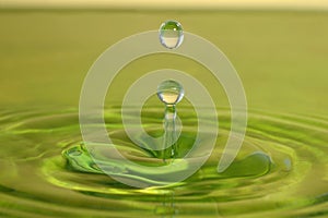 Green drop fall on water surface