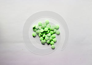 Green drug pills in pile on white background