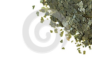 Green Dry food in the form of flakes for aquarium fish on a white background. View from above