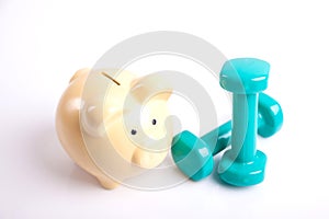 Green dumbbells with piggy bank for health insurance concept