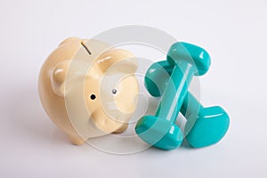 Green dumbbells with piggy bank for health insurance concept