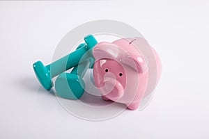 Green dumbbells with piggy bank for health insurance concept