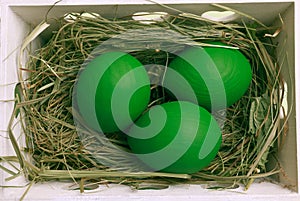 Green Easter eggs in white basket.