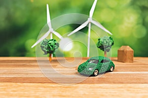 Green eco car and windmill turbine model on office table design. Alter