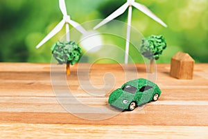 Green eco car and windmill turbine model on office table design. Alter