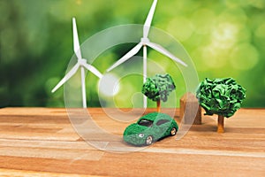Green eco car and windmill turbine model on office table design. Alter