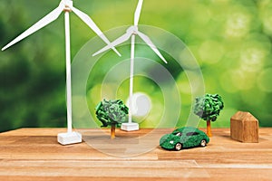 Green eco car and windmill turbine model on office table design. Alter