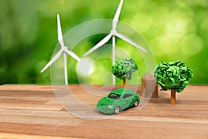 Green eco car and windmill turbine model on office table design. Alter