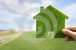 Green ecological house in empty field