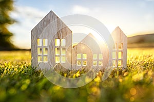 Green ecological wood house in empty field at sunset concept for construction and real estate