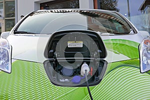 Green electric car charging on the street