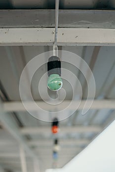 Green electric lamp weighs under the profile roof