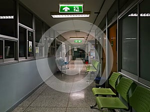 Green emergency exit sign in hospital showing the way to escape at night