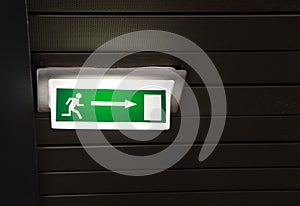 Green emergency exit sign on white