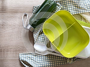 Green empty lunch box wrapped on wooden table , top view or overhead shot , green food concept