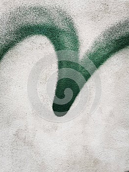 Green emulsified check mark on concrete wall. photo