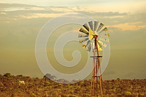 Green energy vintage wind mill sunset background