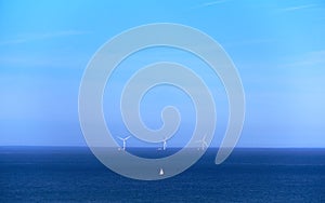 Green energy wind turbine generator in the middle of an ocean, shades of blue