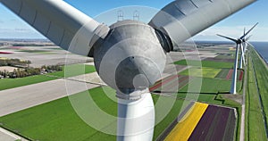 Green energy wind turbine and green grass fiedl along the coast.