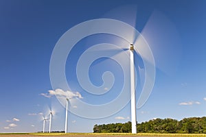 Green Energy Wind Turbines In Field of Sunflowers