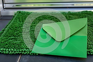 green envelope blending with a green doormat