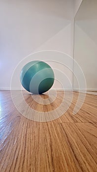 Green exercise ball on wooden floor in modern interior