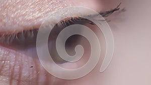 Green eyed model applying black cosmetics mascara on eyelash