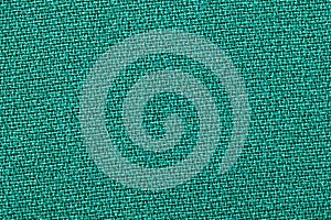 Green fabric background texture. Detail of textile material close-up