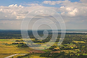 Green farmlands and crop fields on a sunny day near Siem Reap, Cambodia. Aerial view.