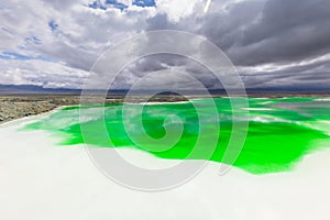 Green Feicui lake with clouds in sky in Qinghai province of China