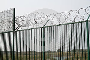 Green fence with razor wire guarding French ferry terminal.