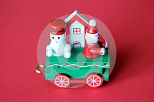 Green festive wooden train car or carriage on red background