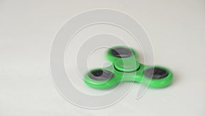 Green fidget spinner turns and stops on white background stock footage video