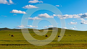 Green field with a cloudy blue sky in the background, perfect for backgrounds and wallpapers