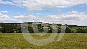 Green field in Hoherodskopf - Vogelsberg under cloudy sky photo