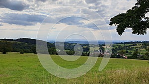 Green field in Hoherodskopf - Vogelsberg under cloudy sky photo