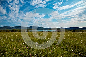 Green field, lake and mountains