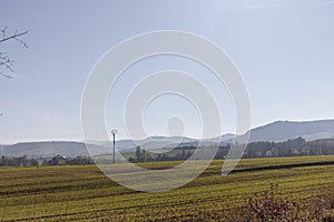 Green field with mountains in the background and electricity poles in Vitoria-Gasteiz, Basque Country, Spain