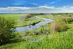 Green field, river and blue sky