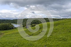 Green field with river under blue sky