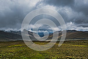 Green field under thunderhead cloudy sky