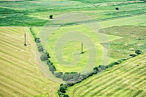 Green fields and high voltage power lines, view from airplane