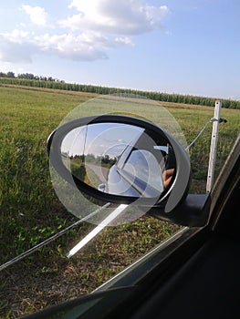 Green fields and rearmirror of car