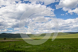 Green fields and white clouds in a blue sky