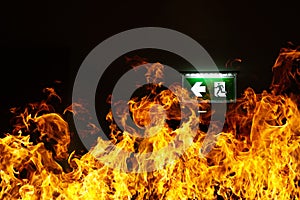 Green fire escape sign hang on the ceiling in the Warehouse. The concept of fire escape training and preparation for evacuation