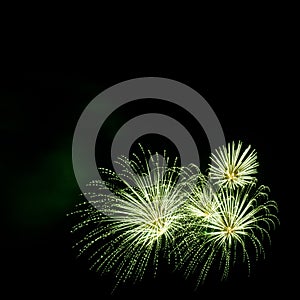 Green fireworks border on the black sky background with copyspace