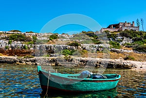 A green fishing boat moored in an inlet near Polignano a Mare, Puglia, Italy photo