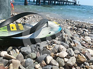 Green flip-flops on the pebble beach